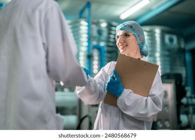 Caucasian female scientist working in laboratory at factory warehouse. Attractive woman chemist analysis of a chemical sample in the scientific research laboratory processing bottles of mineral water. - Powered by Shutterstock