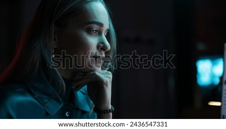 Caucasian Female Smiling While Checking Data and Statistic Charts Using Desktop Computer. Portrait of a Happy Successful Businesswoman in Creative Agency in the Evening