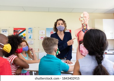 Caucasian Female Teacher Wearing Face Mask At School, Teaching Children At School Classroom. Education Back To School Health Safety During Covid19 Coronavirus Pandemic.