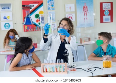 Caucasian female teacher wearing face mask at school, teaching children at school classroom. Education back to school health safety during Covid19 Coronavirus pandemic. - Powered by Shutterstock