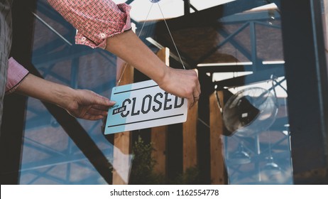 Caucasian female turning sign from open to closed on the entrance door of his small cafe. Out of business - Shutterstock ID 1162554778