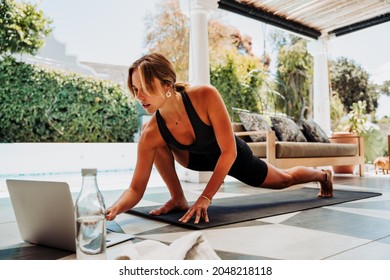 Caucasian Female Watching Video On Laptop Practicing Yoga Outside Home