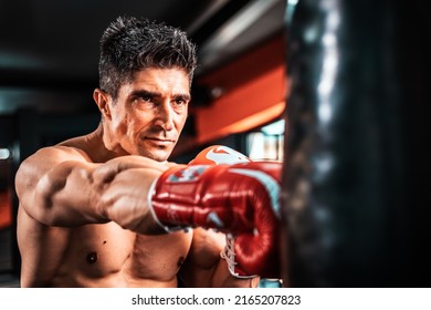 Caucasian fighter man wear boxing red gloves and punching forward with one fist to camera in the fitness sport gym. Make looking forward with serious face. Exercise for a healthy body
 - Powered by Shutterstock