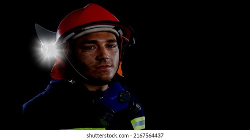 Caucasian Firefighter Wearing A Helmet Against Spot Of Light And Copy Space On Black Background. Safety Concept