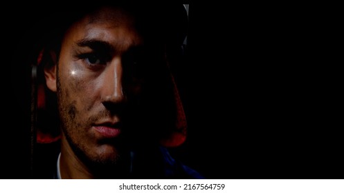 Caucasian Firefighter Wearing A Helmet Against Spot Of Light And Copy Space On Black Background. Safety Concept