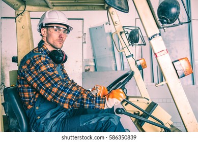 Caucasian Forklift Operator Inside The Forklift. Heavy Duty Workplace Equipment.