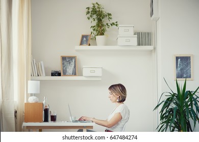 Caucasian freelancer using laptop in modern home office - Powered by Shutterstock