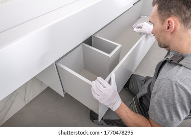 Caucasian Furnishing Technician In His 40s Finishing Modern And Elegant Custom Made Bathroom Furniture. Industrial Theme.