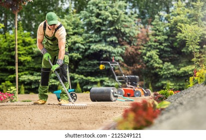 Caucasian Garden Specialist with Rake Preparing Soil For Natural Grass Turfs Installation. Landscaping Theme. - Shutterstock ID 2125249121