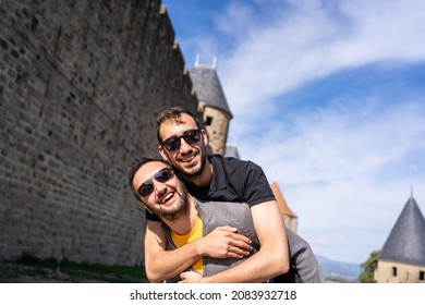 Caucasian gay couple embraced next to the walls of a medieval castle - Powered by Shutterstock