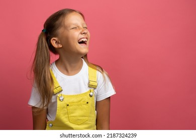 Caucasian Girl Child In Yellow Clothes Waist-length Portrait Looking Away On A Pink Background