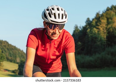 Caucasian Girl Cyclist With Professional Racing Sports Gear Riding On An Open Road Cycling Route