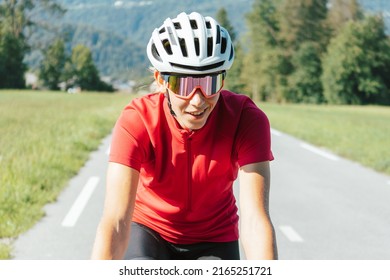 Caucasian Girl Cyclist With Professional Racing Sports Gear Riding On An Open Road Cycling Route