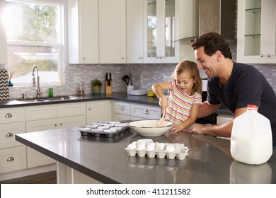 Caucasian Girl And Dad Baking Together In The Kitchen