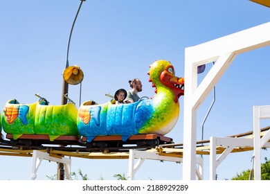 Caucasian Girl With Dad Riding A Carousel, Family Vacation Rollercoaster, Child 4 Years Old On A Dragon Horizontal Photography