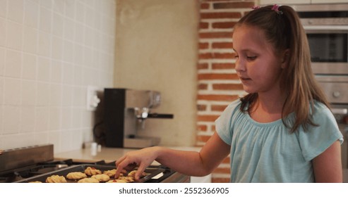 Caucasian girl eating baked cookies in the kitchen at home. social distancing quarantine lockdown during coronavirus pandemic concept - Powered by Shutterstock