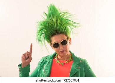 A Caucasian Girl In A Green Dress And With Green Hair Is Preparing For The Holidays. Suit Of The Teacher Of Primary Classes. The Concept Of Happy Holidays And Good Mood.