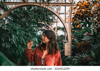 caucasian girl in nice dress red jacket smiling calm and relaxed walking inside calm and quiet botanic garden, botanic garden christchurch, new zealand - Shutterstock ID 2224512299