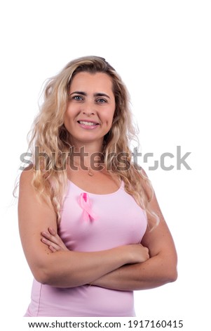 Caucasian girl with pink t-shirt holding breast cancer ribbon over a white background.