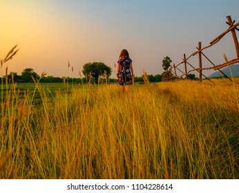 Caucasian Girl Walking Around The Farm Stay And Brown Grass In The Foreground