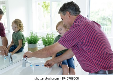 Caucasian grandfather in bathroom brushing teeth with grandson sitting beside basin. staying at home in isolation during quarantine lockdown. - Powered by Shutterstock