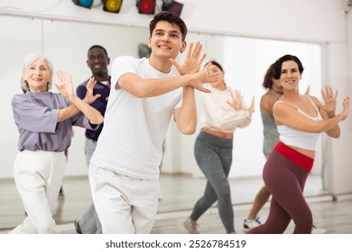 Caucasian guy practising dance moves with other people in dance studio - Powered by Shutterstock