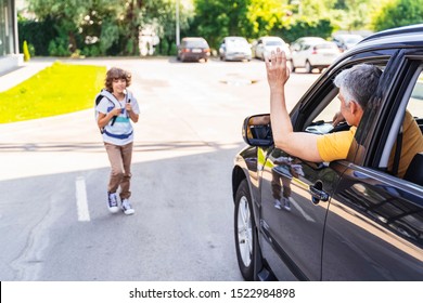 Caucasian Guy Waving With Hand To Little Son Near Car. Family Relationship Concept