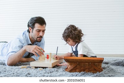 Caucasian Handsome Father Playing Toys With His Little Cute Daughter At Home After Work. Family And Education Concept