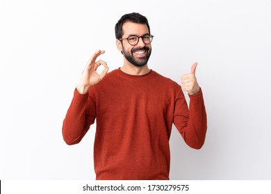 Caucasian handsome man with beard over isolated white background showing ok sign and thumb up gesture