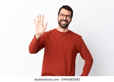 Caucasian handsome man with beard over isolated white background saluting with hand with happy expression - Powered by Shutterstock