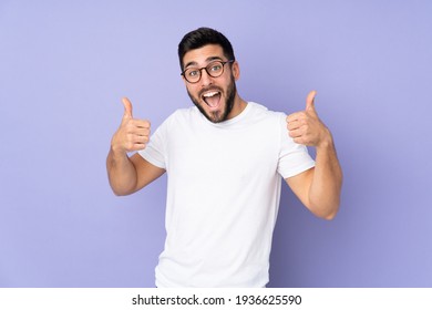 Caucasian handsome man over isolated background giving a thumbs up gesture