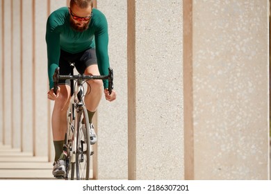 Caucasian Handsome Young Man In Protective Helmet Goes Out For Bicycle Ride Through City Streets On Blurred Background. Cyclist Male Ride Bike Outdoors In Urban.