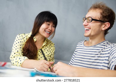 Caucasian Happy Young Man Talking With A Chinese Girl Is Language Teacher