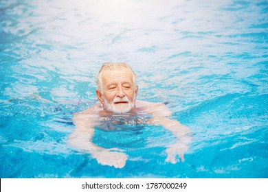 Caucasian healthy elder swimming at the swimming pool for relax in summer holiday activity - Powered by Shutterstock