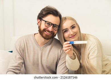 Caucasian Heterosexual Couple Happily Showing Pregnancy Test To The Camera. High Quality Photo