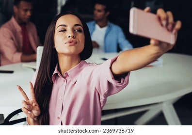 Caucasian hipster girl with duck face clicking selfie photos via modern mobile phone