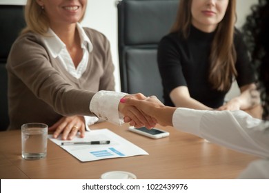 Caucasian hr manager welcoming african applicant at job interview, diverse businesswomen handshaking at group meeting, good first impression and female teamwork, women business partnership concept