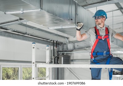 Caucasian HVAC Professional Worker in HIs 40s Checking Last Points of the System From Aluminium Scaffolding. Heating and Cooling Industry Theme.