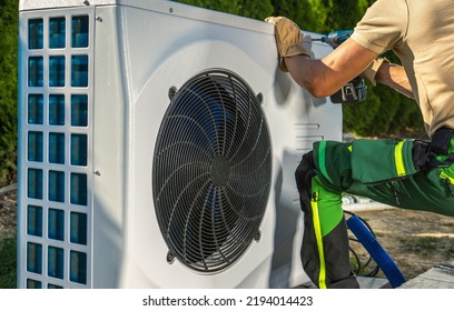 Caucasian HVAC Worker Installing Electric Modern And Energy Saving Heat Pump. 