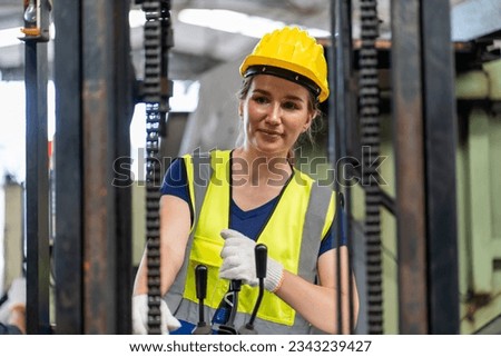 caucasian Industry engineer worker woman wearing safety uniform and hard hat control stick of truck crane or forklift In Industrial Factory warehouse .
