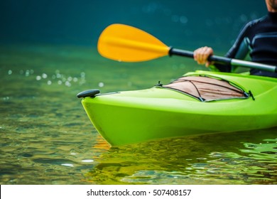 Caucasian Kayaker On The River Telephoto Closeup. Kayak Trip.