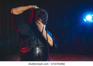 caucasian kendo fighter before wearing all outfit, fighter man wearing protective helmet on head. kendo concept - Powered by Shutterstock