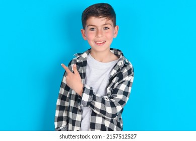 caucasian kid boy wearing plaid shirt over blue background pointing away and smiling to you. Look over there! - Shutterstock ID 2157512527