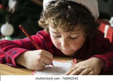 Caucasian Kid Writing A Christmas Wishlist