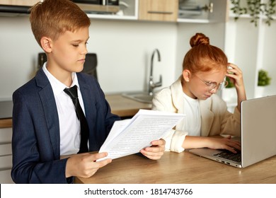 caucasian kids entered the role of adults, work on laptop with documents and papers at home. young business people have conversation, during quarantine indoors, online - Powered by Shutterstock