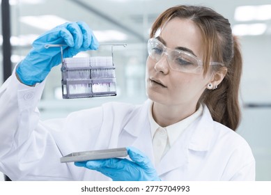 Caucasian laboratory pathologist using automatic multi slide stainer machine in a laboratory