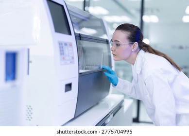 Caucasian laboratory pathologist using automatic multi slide stainer machine in a laboratory