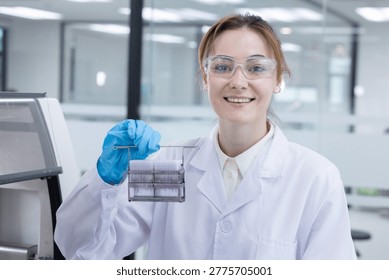 Caucasian laboratory pathologist using automatic multi slide stainer machine in a laboratory