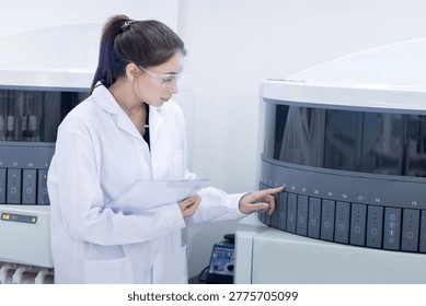 Caucasian laboratory pathologist using automatic multi slide stainer machine in a laboratory