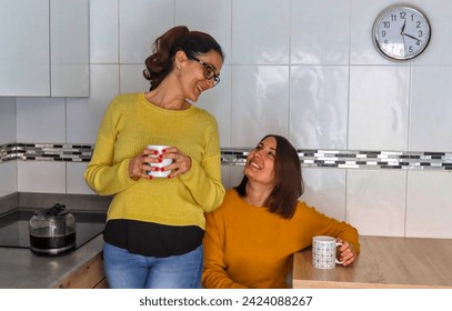 Caucasian lesbian couple having a delicious coffee happily in the kitchen, getting ready to start the day. LGBT couple concept - Powered by Shutterstock